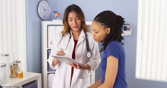 African American patient explaining issues to Asian doctor using tablet | Image Credit: © rocketclips - stock.adobe.com
