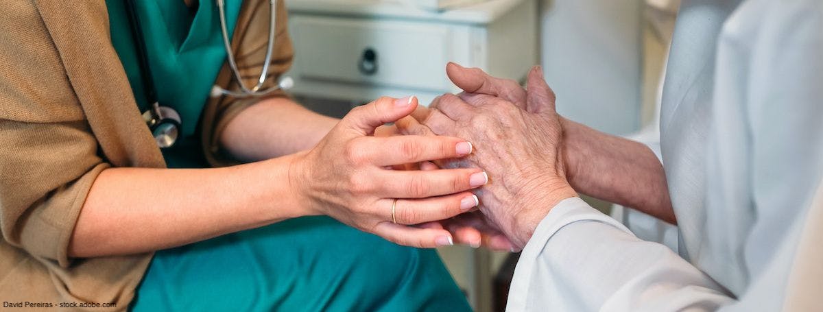 female doctor holding the hands of an elderly patient