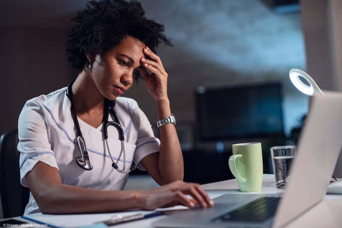 African American female doctor with headache working on laptop | Image Credit: © Drazen - stock.adobe.com 