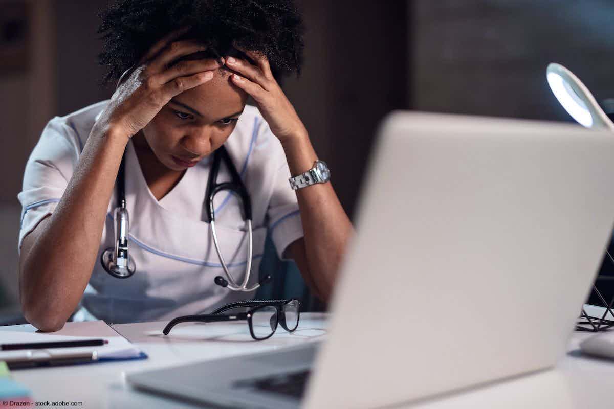 African American doctor having headache while reading an e-mail on laptop | Image Credit: © Drazen - stock.adobe.com