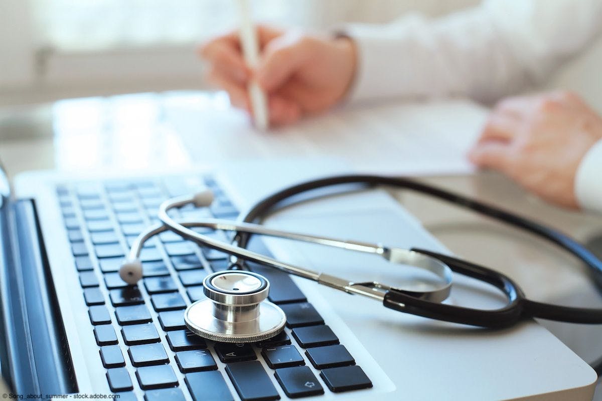 Doctor reviewing a document near a laptop and stethoscope | Image Credit: © Song_about_summer - stock.adobe.com