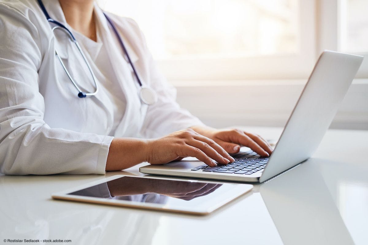 woman doctor typing on laptop