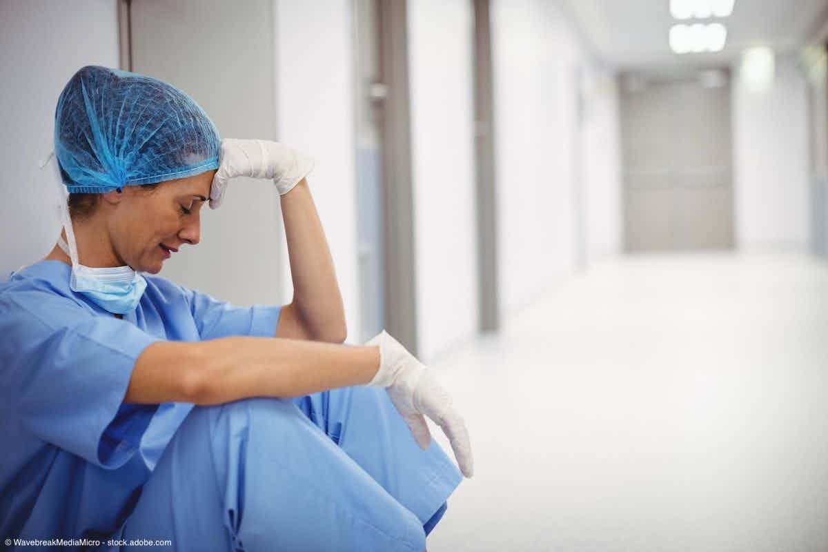Sad surgeon sitting on floor in corridor | Image Credit: © WavebreakMediaMicro - stock.adobe.com